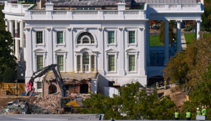 Construction workers, bottom right, atop the U.S. Treasury, watch as work continues on a largely demolished part of the East Wing of the White House on Oct. 23, 2025, before construction of a new ballroom. (AP Photo/Jacquelyn Martin)