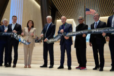 JPMorgan Chase CEO Jamie Dimon, fourth from left, cuts the ribbon on a new JPMorgan Chase building during a ceremony in New York, Tuesday, Oct. 21, 2025. Also holding the ribbon, from left to right: Jerry Speyer, Rob Speyer, NY Governor Kathy Hochul, Dimon, Norman Foster, Deepak Chopra and David Arena. (AP Photo/Seth Wenig)