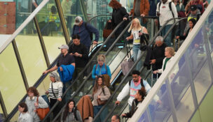 Travellers head tdown an escalator after clearing through a security checkpoint in Denver International Airport Friday, Nov. 7, 2025, in Denver. (AP Photo/David Zalubowski)