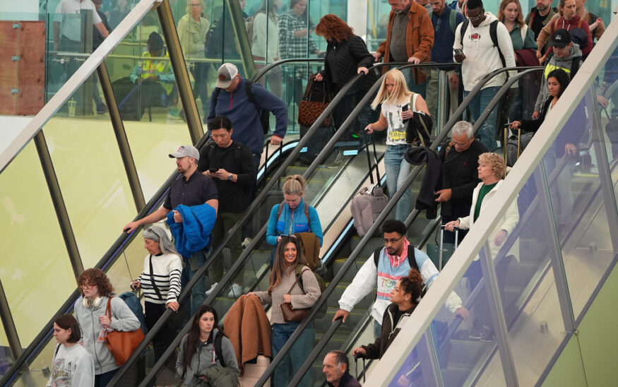 Travellers head tdown an escalator after clearing through a security checkpoint in Denver International Airport Friday, Nov. 7, 2025, in Denver. (AP Photo/David Zalubowski)
