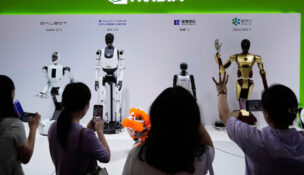 FILE - Visitors give commands to robots at Nvidia's booth during the China International Supply Chain Expo at the China International Exhibition Center in Beijing, China, July 18, 2025. (AP Photo/Mahesh Kumar A., File)