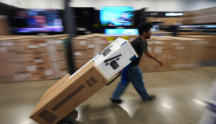 A Best Buy employee hauls early Black Friday sale items at Best Buy Thursday, Nov. 20, 2025, in San Diego. (AP Photo/Gregory Bull)