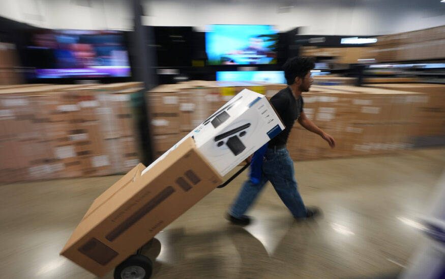 A Best Buy employee hauls early Black Friday sale items at Best Buy Thursday, Nov. 20, 2025, in San Diego. (AP Photo/Gregory Bull)