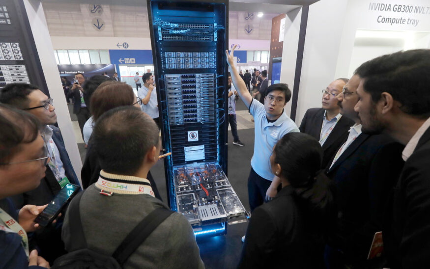 Visitors listen to the introduction of NVIDIA GB300 NVL72 AI server during the Hon Hai Tech Day (HHTD 25) at the Nangang Exhibition Center in Taipei, Taiwan, Friday, Nov. 21, 2025. (AP Photo/Chiang Ying-ying)