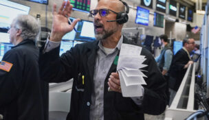 Options trader Steven Rodriguez works on the floor of the New York Stock Exchange, Friday, Nov. 21, 2025. (AP Photo/Richard Drew)