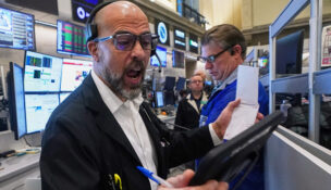 Options trader Steven Rodriguez, left, works on the floor of the New York Stock Exchange, Monday, Nov. 24, 2025. (AP Photo/Richard Drew)