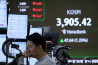A currency trader watches monitors near a screen showing the Korea Composite Stock Price Index (KOSPI) at the foreign exchange dealing room of the Hana Bank headquarters in Seoul, South Korea, Wednesday, Nov. 26, 2025. (AP Photo/Ahn Young-joon)