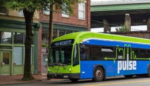 A green and blue bus is driving down a street. The bus is labeled with the word "Pulse" on the side. Richmond, Virginia. USA