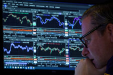 FILE PHOTO: A specialist trader works inside a booth on the floor at the New York Stock Exchange (NYSE) in New York City, U.S., November 19, 2025. REUTERS/Brendan McDermid//File Photo