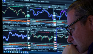 FILE PHOTO: A specialist trader works inside a booth on the floor at the New York Stock Exchange (NYSE) in New York City, U.S., November 19, 2025. REUTERS/Brendan McDermid//File Photo