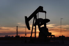 FILE PHOTO: A drone view of a pump jack and drilling rig south of Midland, Texas, U.S. June 11, 2025. REUTERS/Eli Hartman/File Photo