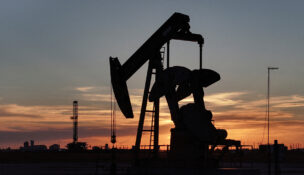 FILE PHOTO: A drone view of a pump jack and drilling rig south of Midland, Texas, U.S. June 11, 2025. REUTERS/Eli Hartman/File Photo