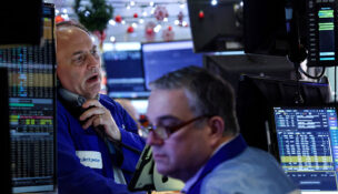 FILE PHOTO: Traders work on the floor at the New York Stock Exchange (NYSE) in New York City, U.S., December 17, 2025. REUTERS/Brendan McDermid/File Photo