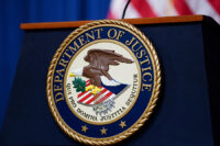 FILE PHOTO: The seal of the U.S. Justice Department is seen on the podium in the Department's headquarters briefing room before a news conference with the Attorney General in Washington, January 24, 2023. REUTERS/Kevin Lamarque/File Photo