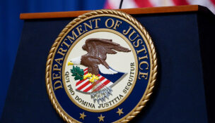 FILE PHOTO: The seal of the U.S. Justice Department is seen on the podium in the Department's headquarters briefing room before a news conference with the Attorney General in Washington, January 24, 2023. REUTERS/Kevin Lamarque/File Photo