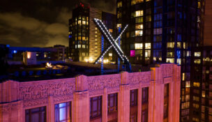 FILE - Workers install lighting on an "X" sign atop the company headquarters in downtown San Francisco, July 28, 2023. (AP Photo/Noah Berger, File)