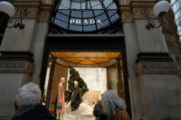 Customers look at a Prada shop window, in Milan, Italy, Tuesday, Dec. 2, 2025. (AP Photo/Luca Bruno)