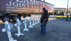 FILE - Allen Wilson, right, hugs an attendee after they wrote on crosses for victims during a vigil Thursday, Nov. 6, 2025, in Louisville, Ky., after a UPS plane crashed at Louisville Muhammad Ali International Airport. (AP Photo/Darron Cummings, File)