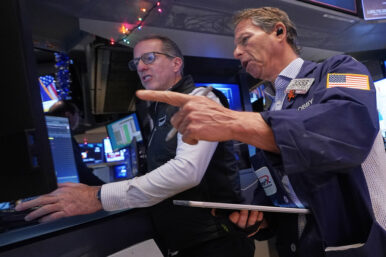 Specialist Glenn Carell, left, and trader Robert Charmak work on the floor of the New York Stock Exchange, Thursday, Dec. 11, 2025. (AP Photo/Richard Drew)