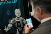 A man records a humanoid robot inside the exhibition room at the Humanoids Summit, Thursday, Dec. 11, 2025, in Mountain View, Calif. (AP Photo/Godofredo A. Vásquez)