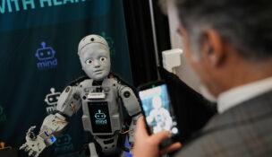 A man records a humanoid robot inside the exhibition room at the Humanoids Summit, Thursday, Dec. 11, 2025, in Mountain View, Calif. (AP Photo/Godofredo A. Vásquez)