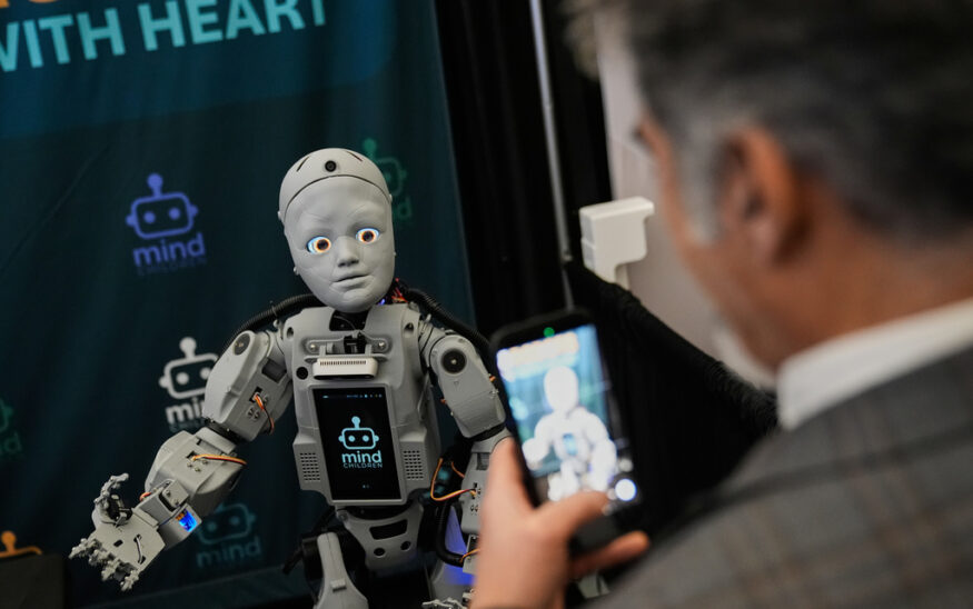 A man records a humanoid robot inside the exhibition room at the Humanoids Summit, Thursday, Dec. 11, 2025, in Mountain View, Calif. (AP Photo/Godofredo A. Vásquez)