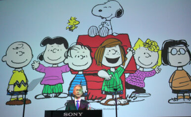 FILE - Sony Corp. President Kenichiro Yoshida speaks as characters from Peanuts are shown at a press conference at the company's headquarters Tuesday, May 22, 2018, in Tokyo. (AP Photo/Eugene Hoshiko, File)