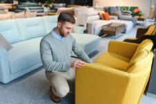 Young man looking for new chair for home at furniture warehouse. Photo: Depositphotos