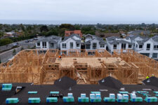 A drone view shows construction personnel working on a multi-home residential project by Shea Homes in Encinitas, California, U.S. July 21, 2025. REUTERS/Mike Blake/File Photo