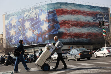People walk past an anti-U.S. billboard in Tehran, Iran, February 19, 2026. Majid Asgaripour/WANA (West Asia News Agency) via REUTERS