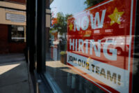 A "Now Hiring" sign hangs in the window of a hair salon in the Greater Boston town of Medford, Massachusetts, U.S., August 12, 2025. REUTERS/Brian Snyder