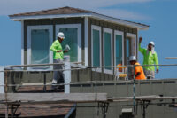 Construction workers paint a residential housing project, in Carlsbad, California, U.S. July 8, 2025. REUTERS/Mike Blake/File Photo