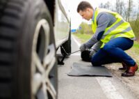 Man changing wheel on a roadside. Depositphotos