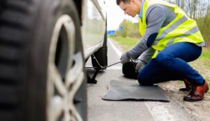 Man changing wheel on a roadside. Depositphotos