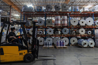 An employee operates a machine next to rolls of plastic to produce grocery bags at Emerald Packaging in Union City, California, U.S., April 6, 2026. REUTERS/Carlos Barria