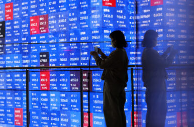 A visitor stands next to an electronic screen displaying Japan's Nikkei stock prices quotation board inside a conference hall in Tokyo, Japan March 4, 2026. REUTERS/Issei Kato/ File Photo