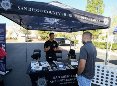 Job seeker Rueben Cota talks with recruiter San Diego sheriff's deputy Hubbard during a job fair for employees who are not vaccinated against the coronavirus disease (COVID-19), in Temecula, California, U.S., December 4, 2021. REUTERS/Denis Poroy