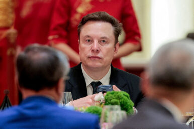 Tesla CEO Elon Musk holds a mobile phone as he arrives to attend a state banquet with U.S. President Donald Trump and Chinese President Xi Jinping at the Great Hall of the People in Beijing, China, May 14, 2026. REUTERS/Evan Vucci//File Photo
