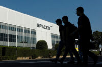 SpaceX employees cross the road as they go to work at the SpaceX facility in Hawthorne on the day of their company's IPO, in Hawthorne, California, U.S. June 12, 2026. REUTERS/Mike Blake