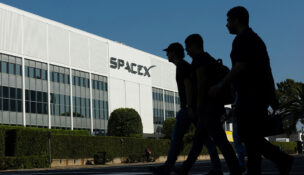 SpaceX employees cross the road as they go to work at the SpaceX facility in Hawthorne on the day of their company's IPO, in Hawthorne, California, U.S. June 12, 2026. REUTERS/Mike Blake