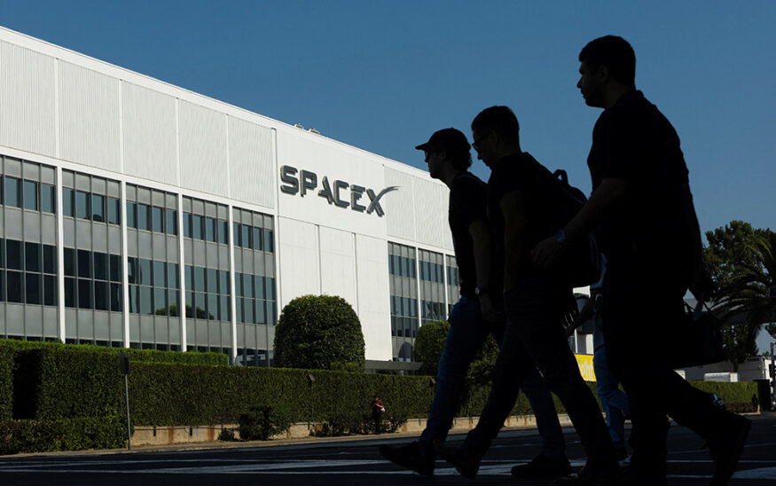 SpaceX employees cross the road as they go to work at the SpaceX facility in Hawthorne on the day of their company's IPO, in Hawthorne, California, U.S. June 12, 2026. REUTERS/Mike Blake
