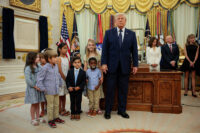 Children pose with U.S. President Donald Trump during an event to mark the launch of "Trump Accounts" in the Oval Office at the White House in Washington, D.C., U.S., July 6, 2026. REUTERS/Evan Vucci