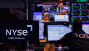 FILE PHOTO: A trader works on the floor of the New York Stock Exchange (NYSE), in New York City