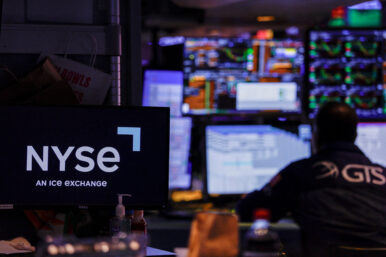 FILE PHOTO: A trader works on the floor of the New York Stock Exchange (NYSE), in New York City
