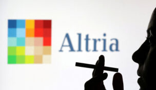 A woman poses with a cigarette in front of Altria logo in this illustration taken July 26, 2022. REUTERS/Dado Ruvic/Illustration/File Photo