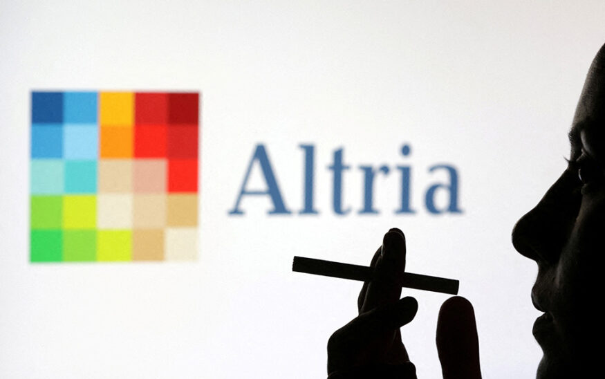 A woman poses with a cigarette in front of Altria logo in this illustration taken July 26, 2022. REUTERS/Dado Ruvic/Illustration/File Photo