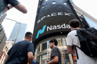 People gather near a SpaceX advertisement outside the Nasdaq MarketSite, on the day of their initial public offering (IPO) in New York City, U.S., June 12, 2026. REUTERS/Brendan McDermid/File Photo
