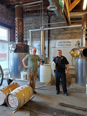 Catoctin Creek Founder and General Manager Scott Harris, (L) and Winchester Police Department officer receiving a donation of hand sanitizer. Photo courtesy Scott Harris