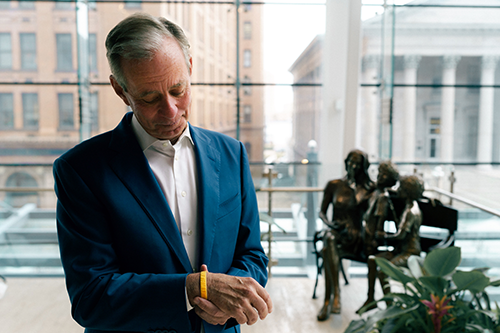 Thompson gazes down at the JT Walk bracelet that belonged to his late son, Josh, who died from ALS in October 2020. Named for Josh, the annual Virginia Beach fundraising event has contributed millions toward ALS research and assisting patients and families. Photo by James Lee