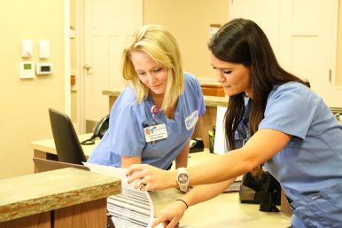Friendship employees confer at a nurse station. Photo courtesy Friendship